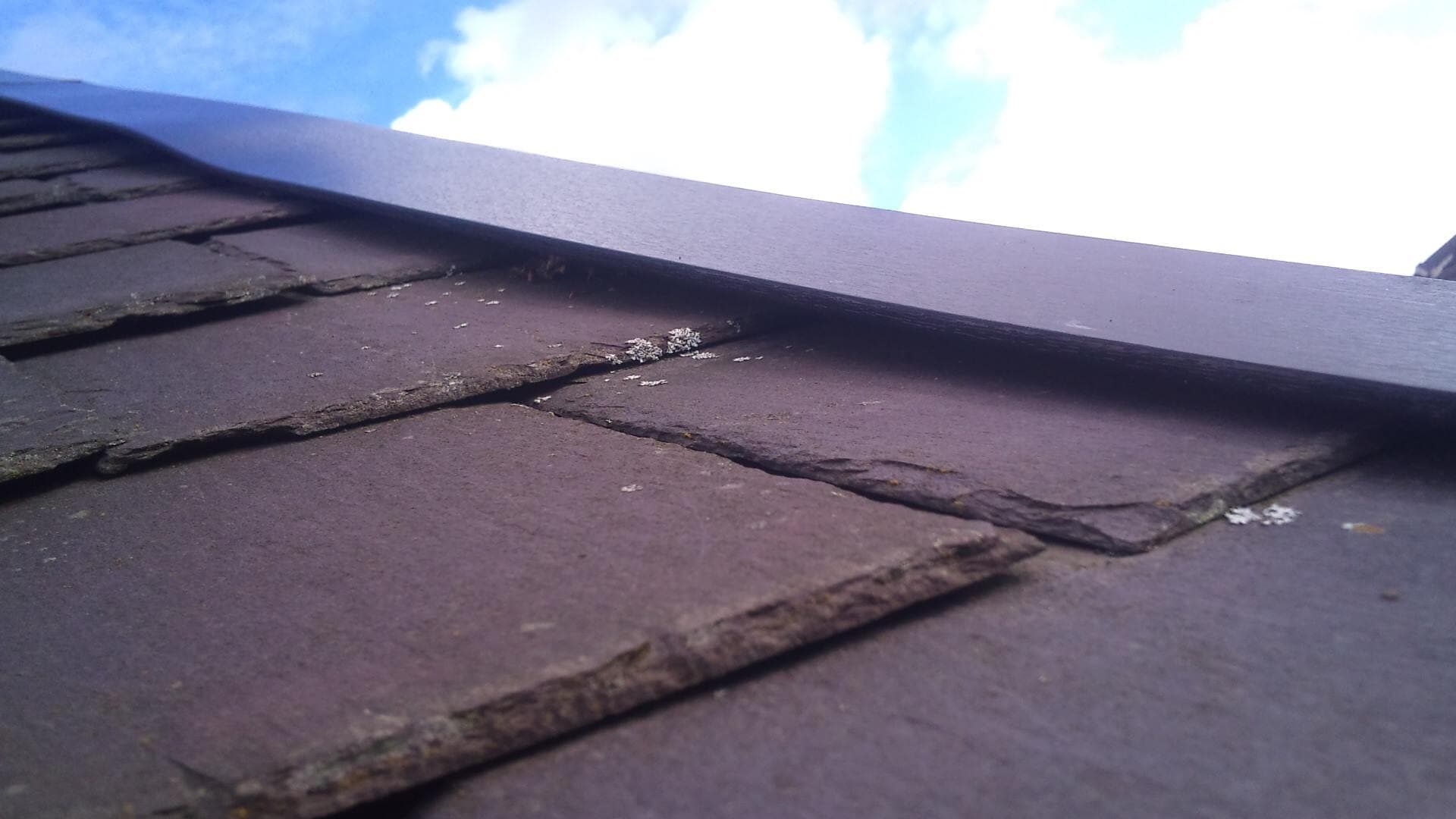 A roofer inspecting and repairing a roof in Leeds
